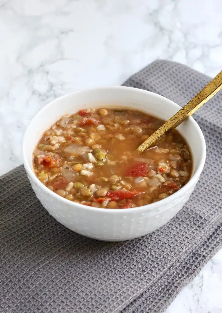 Bowl of lentil soup with gold spoon