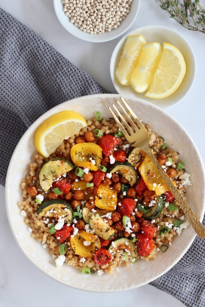 Look for a satisfying meatless meal? Try these Roasted Chickpea Couscous Bowls! This Mediterranean-inspired, vegetarian meal is made with Israeli couscous, colorful veggies, and crispy chickpeas. #IsraeliCouscous #Mediterranean #MeatlessMonday #Vegetarian #HealthyRecipes #RoastedChickpeas