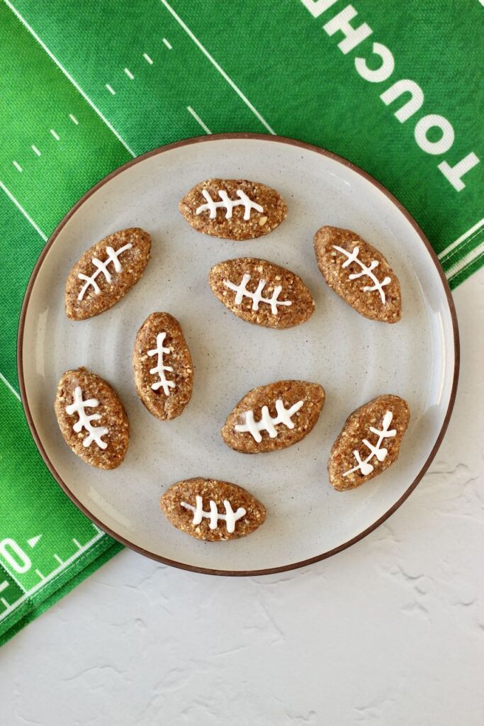 Salted caramel protein energy bites shaped like footballs with white icing laces, perfect for a game day snack