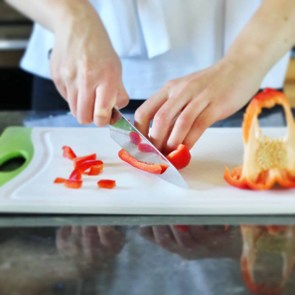 Chopping red bell pepper with bear claw grip