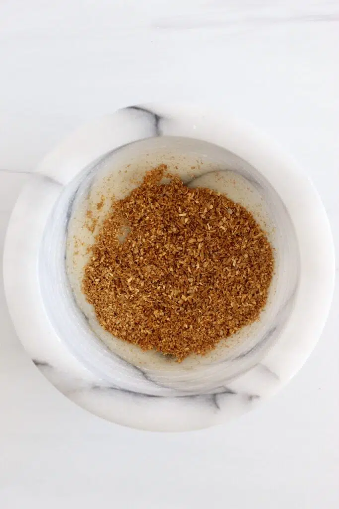 Ground cumin seeds in mortar and pestle