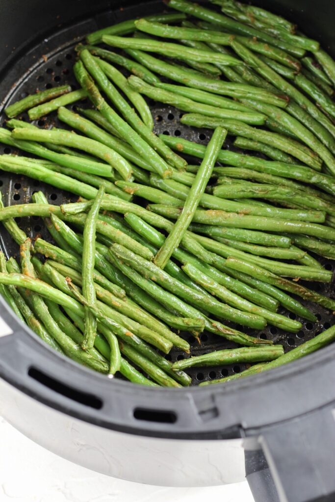 Close up of greens beans in air fryer basket