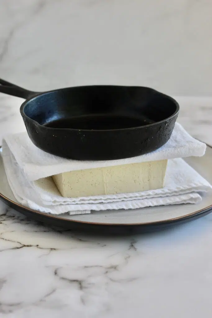 Pressing tofu with a cast iron skillet