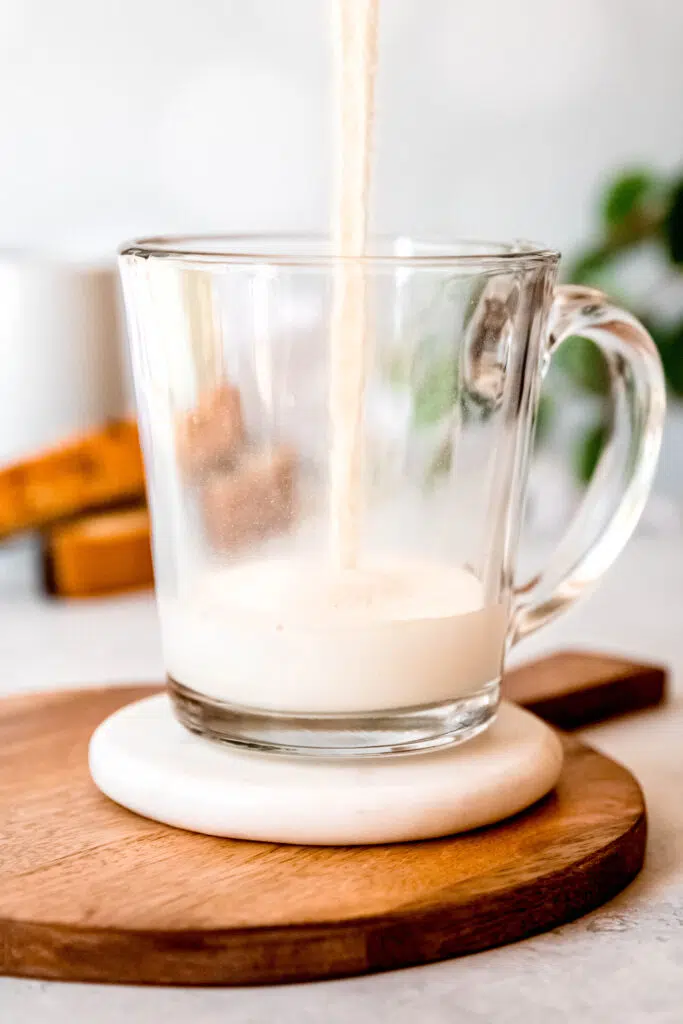 Pouring milk over protein coffee glass