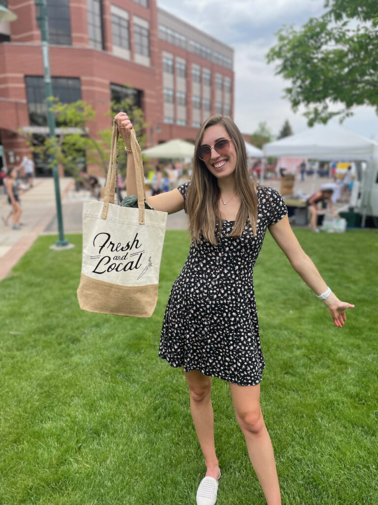 Holding up bag that says fresh and local