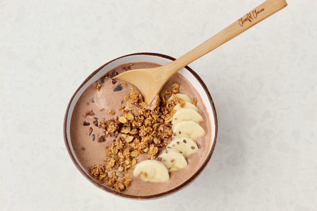 Chocolate smoothie bowl topped with granola and bananas