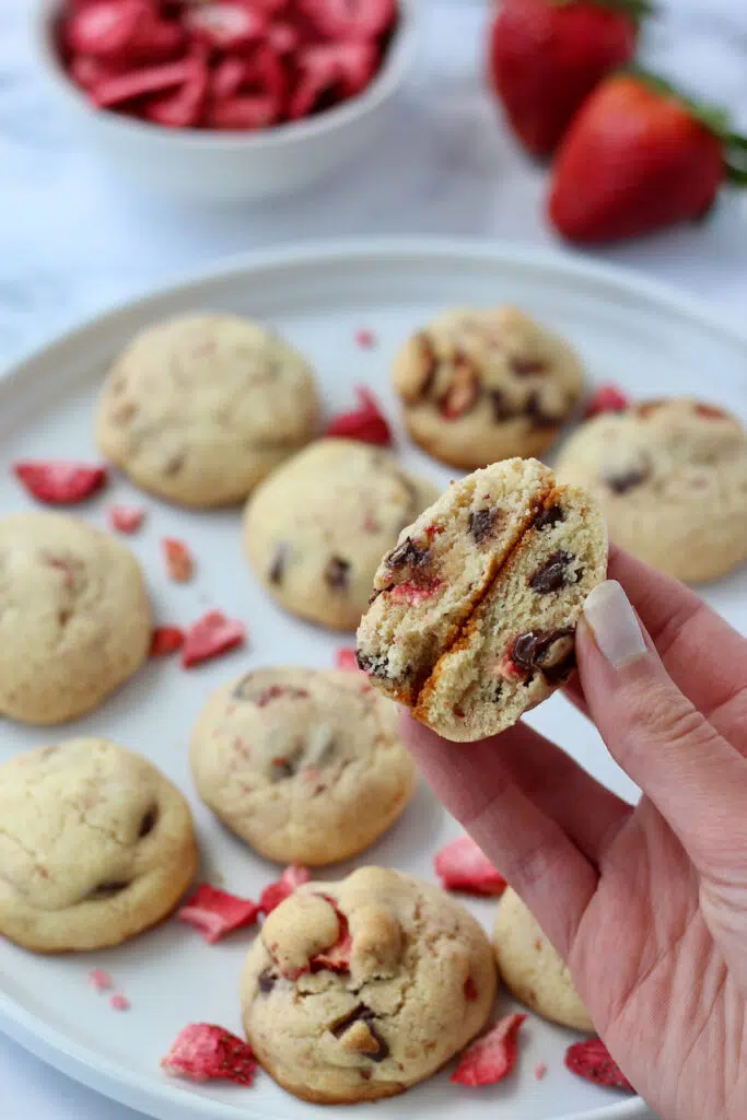 Holding up freshly baked strawberry cookies, perfect blend of sweet and fruity.
