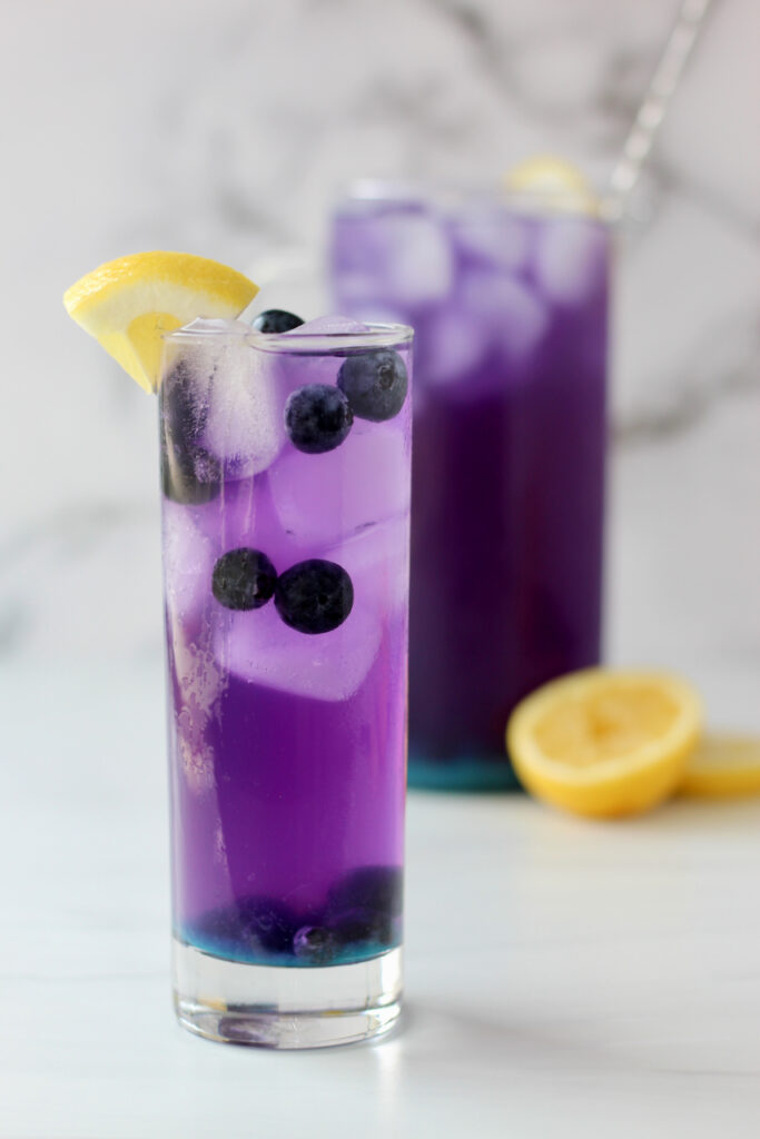 Glass of Blueberry lemonade with a vibrant blue purple hue and a touch of butterfly pea flower