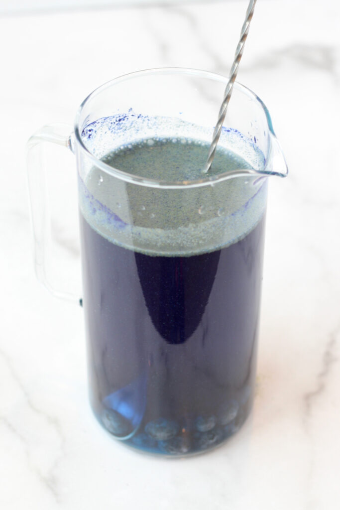 Blueberry-infused lemonade turning from vibrant blue to a delightful shade of purple