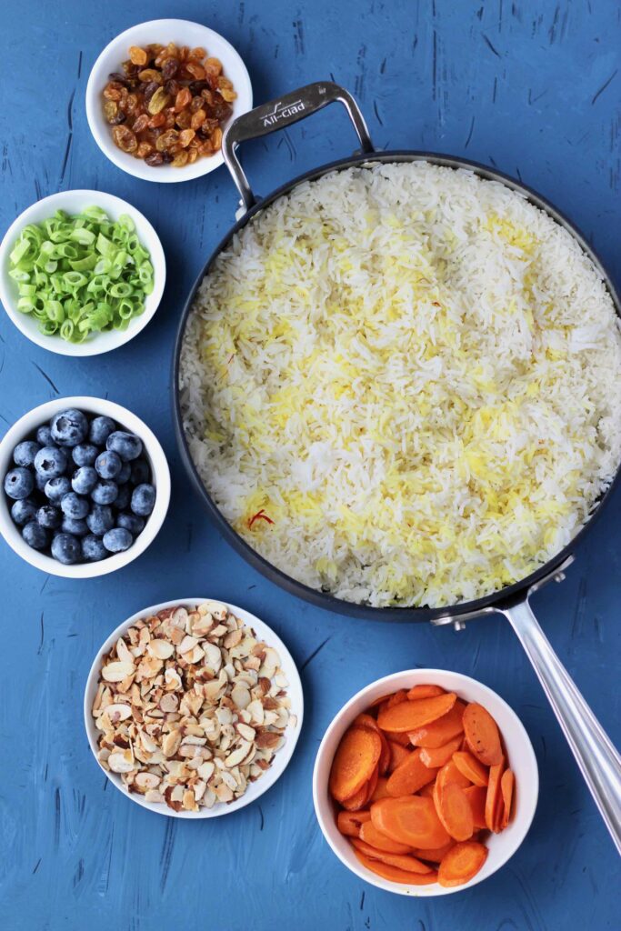 Colorful ingredients next to saffron rice one pot
