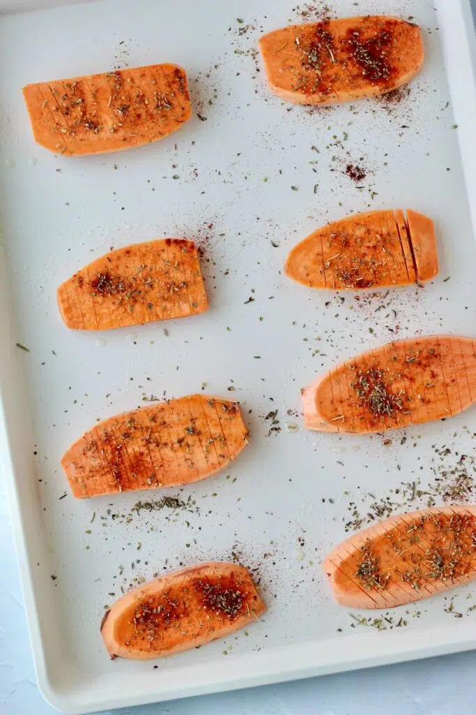 Accordion sweet potatoes on baking sheet with spices of your choice