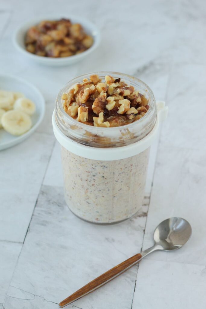 Breakfast jar of banana-flavored overnight oats with a walnut crunch