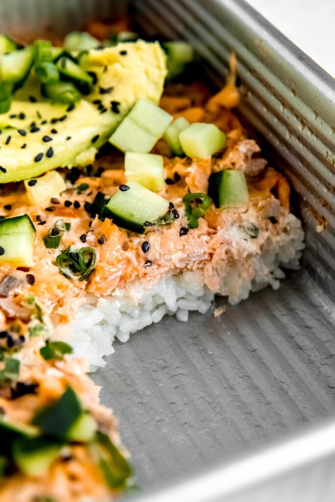 Cut out of Sushi bake with avocado, sesame, and green onion toppings
