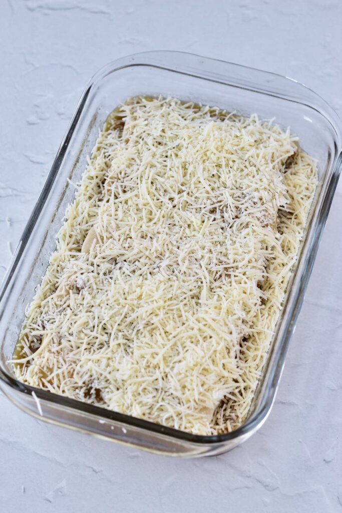 Frozen burritos in pan to bake with cheese on top