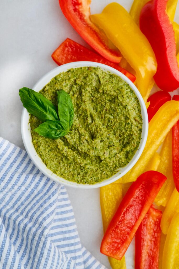 Pesto surrounded by colorful bell peppers
