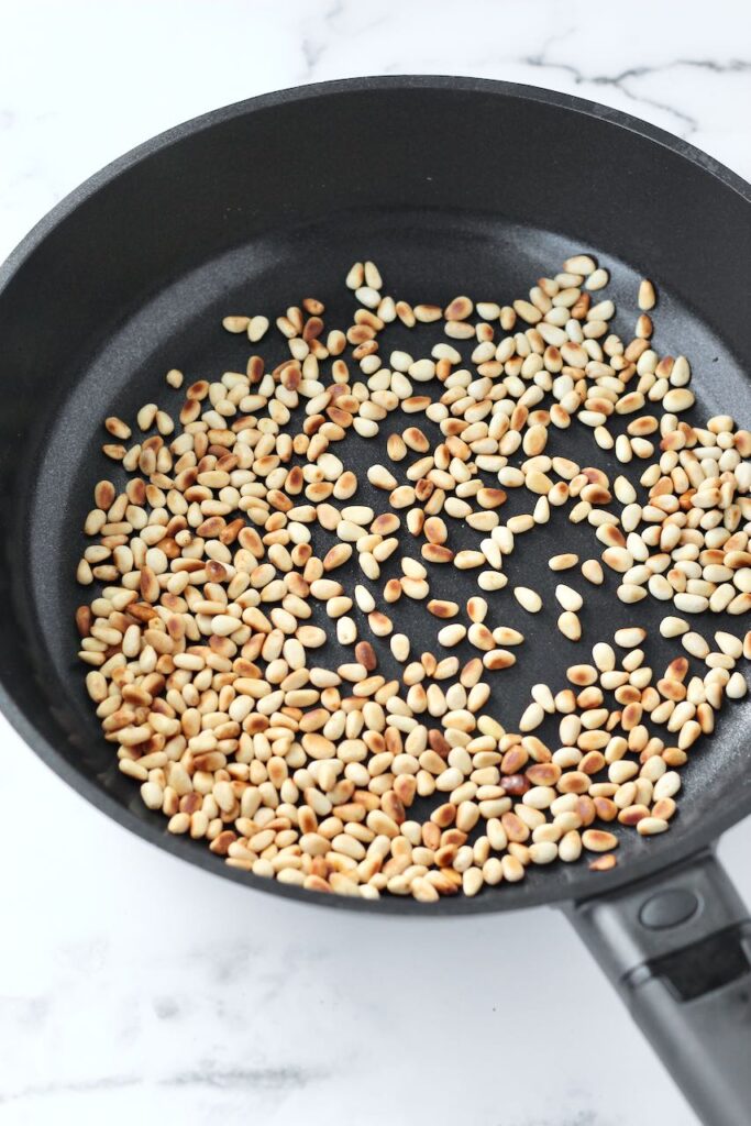 Pine nuts toasting in a pan