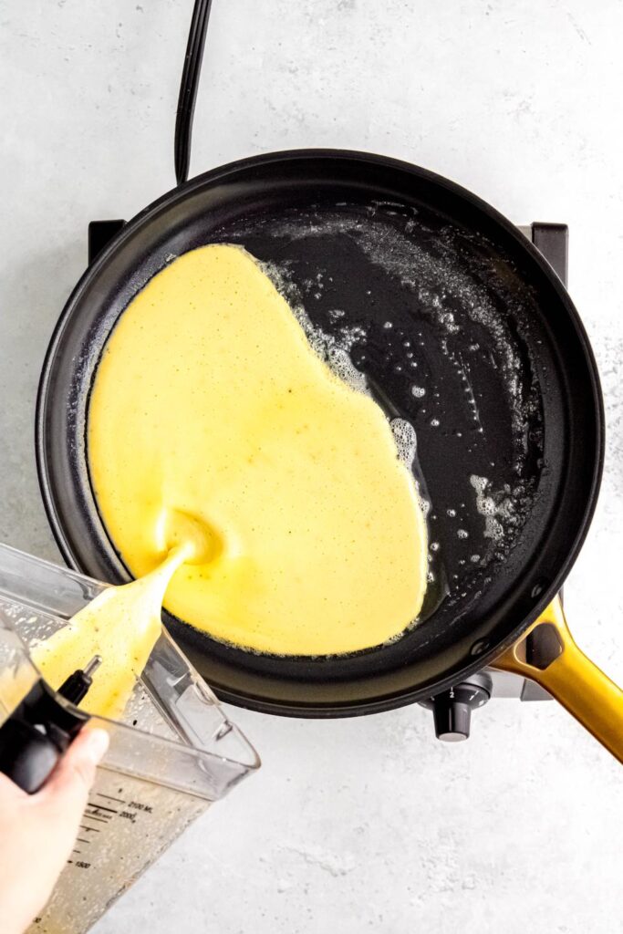 Cottage cheese egg mixture being poured into hot skillet