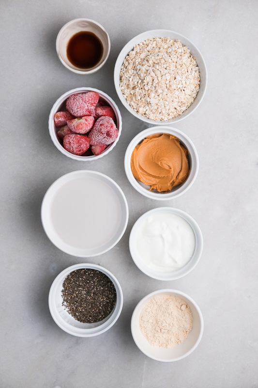 All the ingredients in white bowls for the blended overnight oats