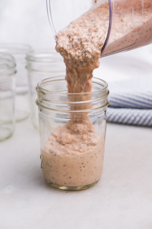 Pouring the blended overnight oats into a mason jar