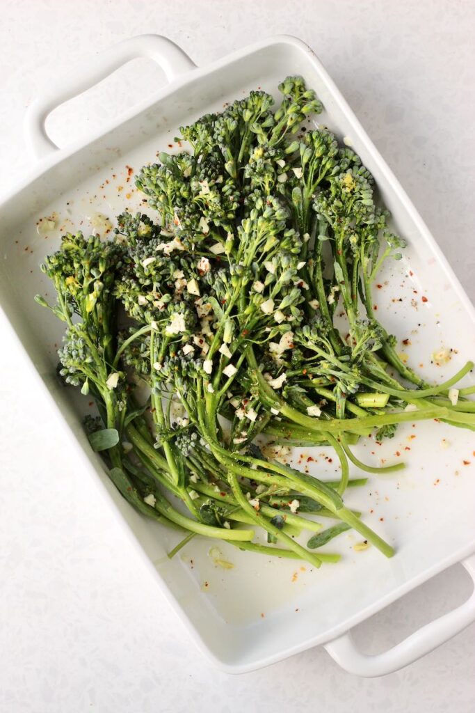 Broccolini in a white pan before cooking