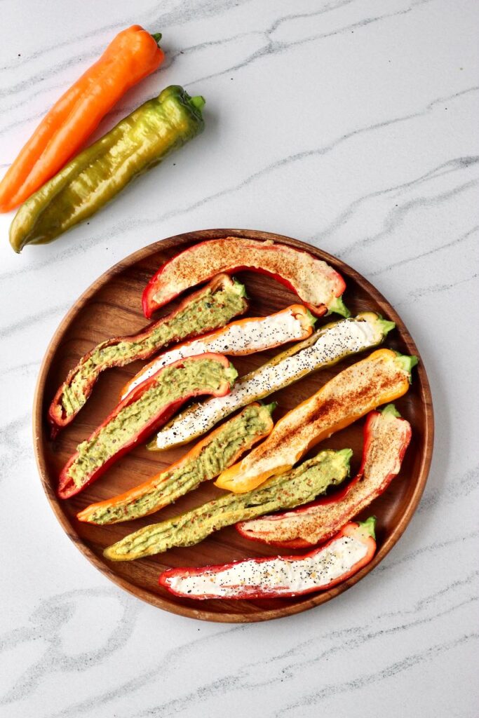 Colorful stuffed mini peppers filled with various toppings on a platter.