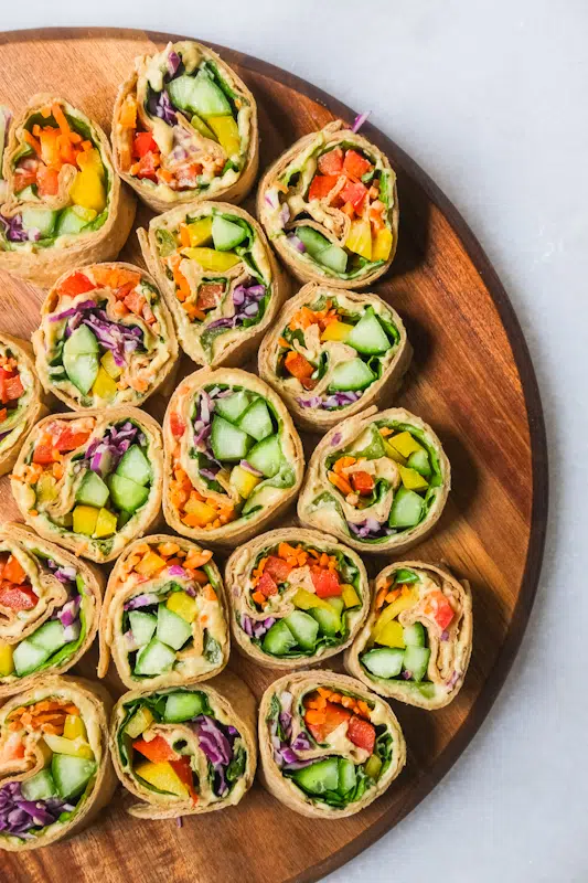 Colorful veggie pinwheels on wood serving board