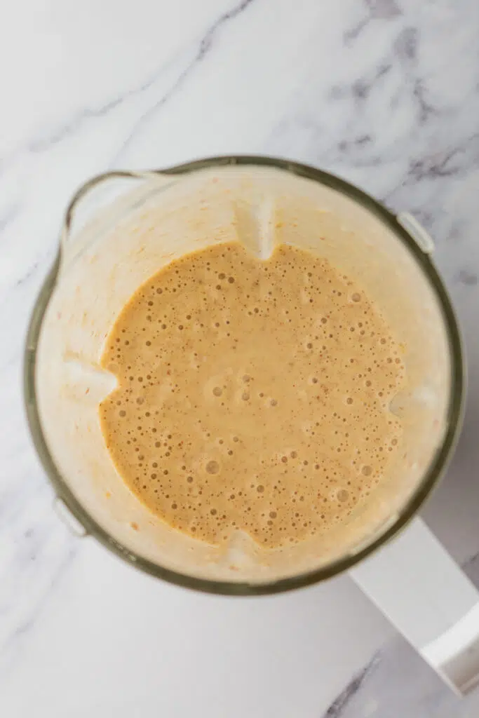 Creamy flaxseed smoothie blend in the blender, ready to be poured.