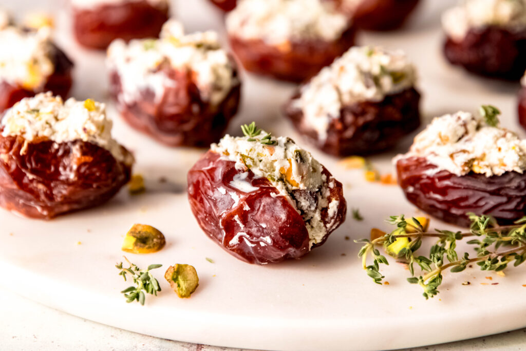 Platter of goat cheese stuffed dates with herbs and pistachios.