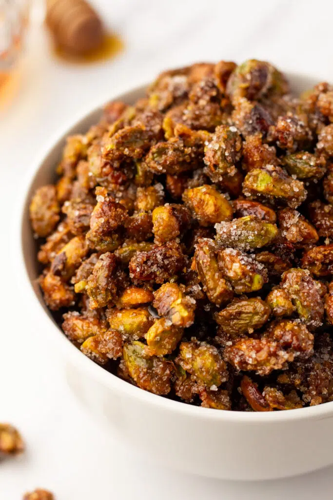 Close up of honey roasted pistachios in white bowl