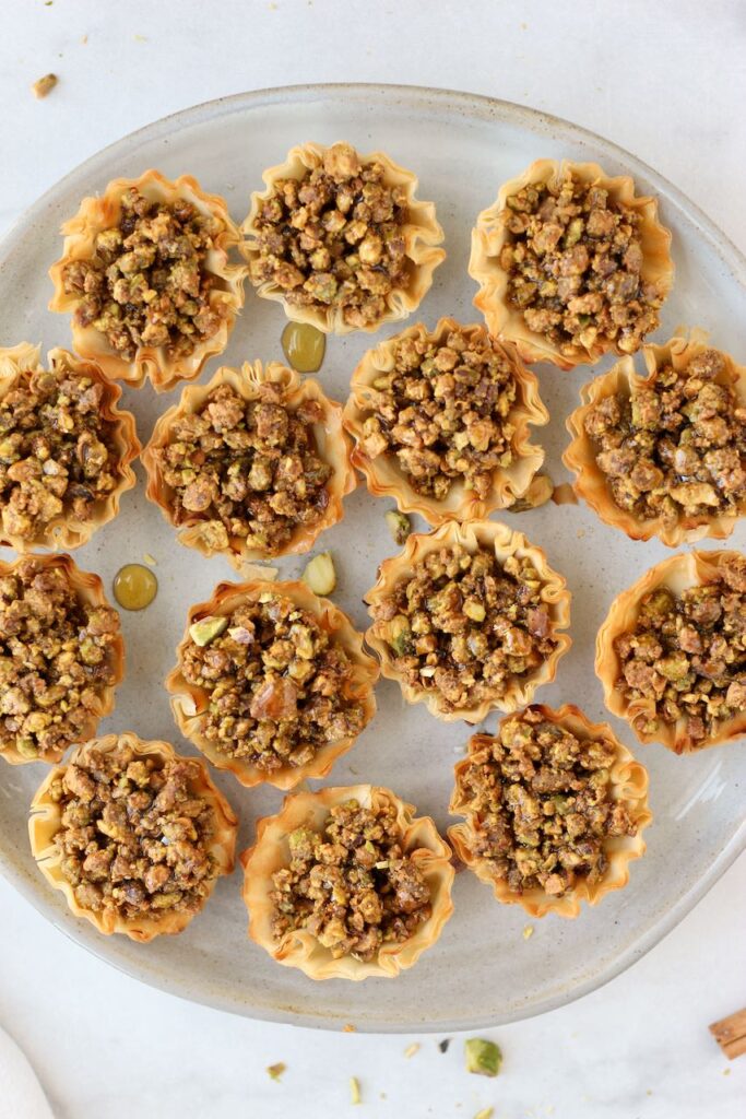 Baklava bites on grey plate drizzled with honey