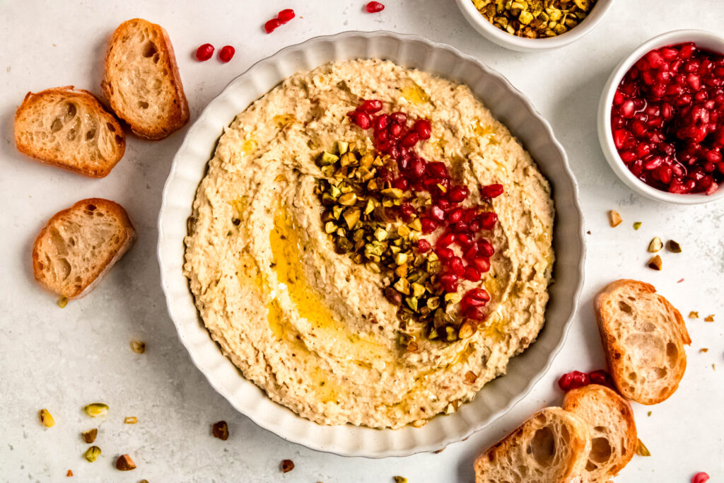 Pistachio and white bean spread with pomegranates, pistachios, and crostinis.