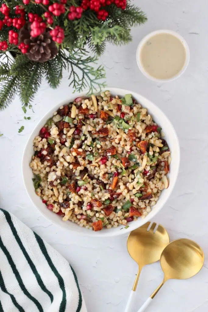 Couscous Salad in white bowl with tahini dressing in bowl