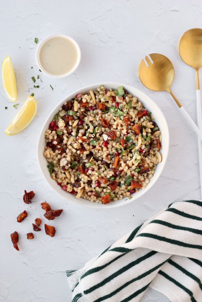 Couscous salad with lemon wedges and serving spoons