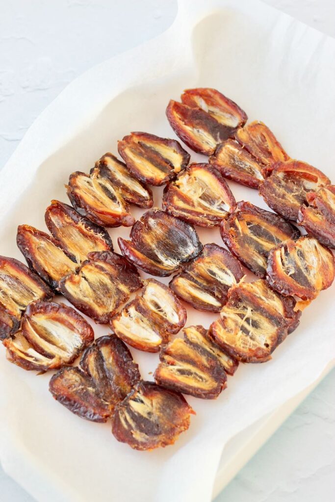 Dates, pitted and laid flat on baking tray