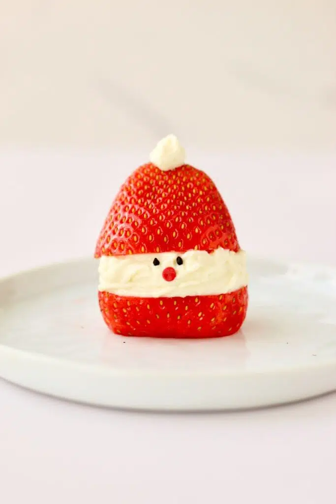 Strawberry Santa hat with poppyseed eyes and red candy nose