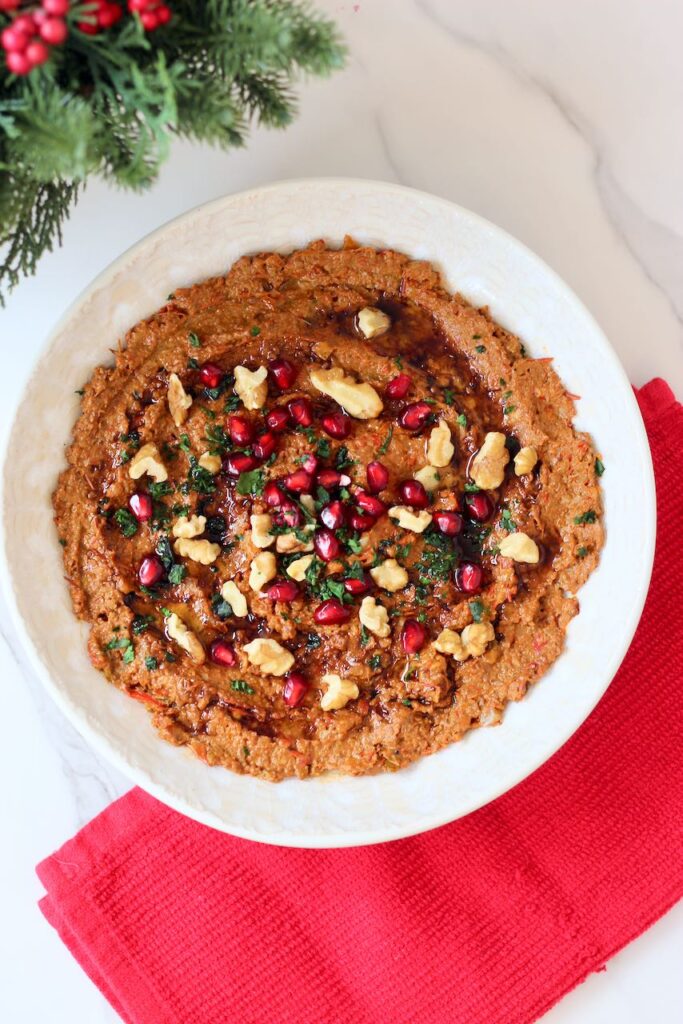 Muhammara with pomegranate seeds, walnuts, and cilantro.