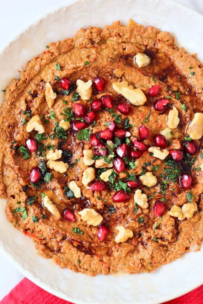 Muhammara with pomegranate seeds, walnuts, and cilantro.