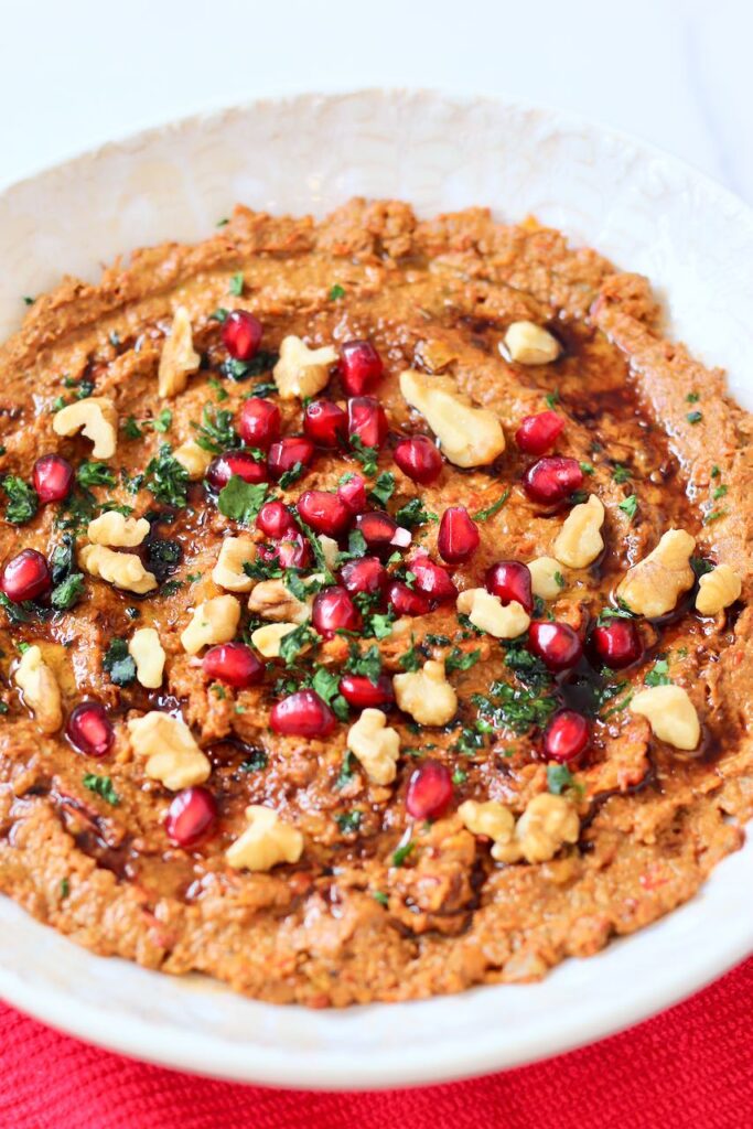 Muhammara with pomegranate seeds, walnuts, and cilantro.