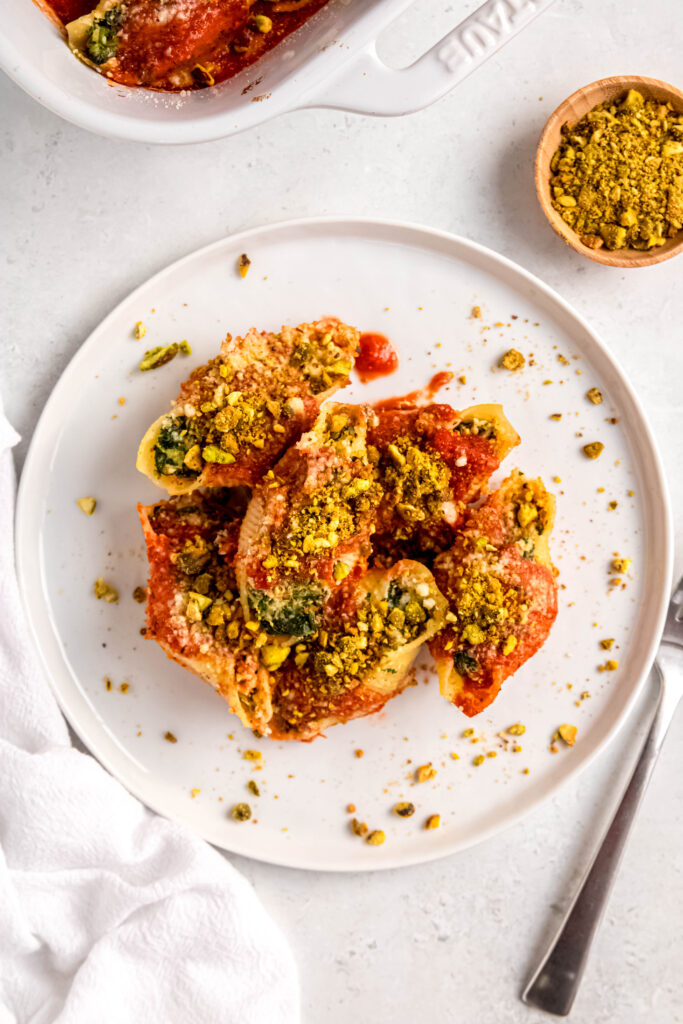 Stuffed shells on white plate with pistachios