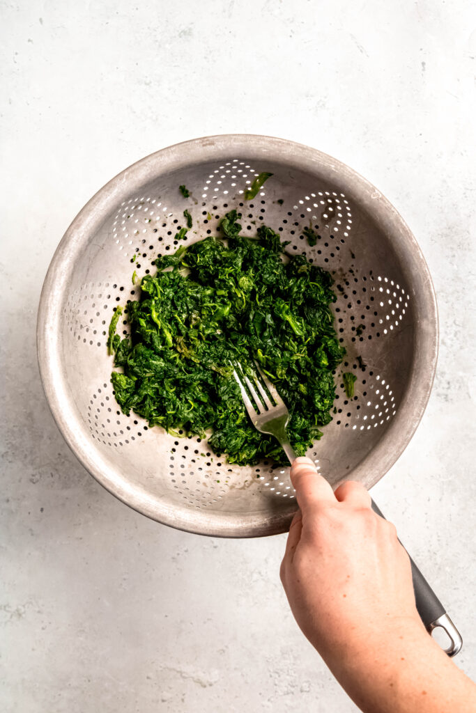 Draining spinach in colander 