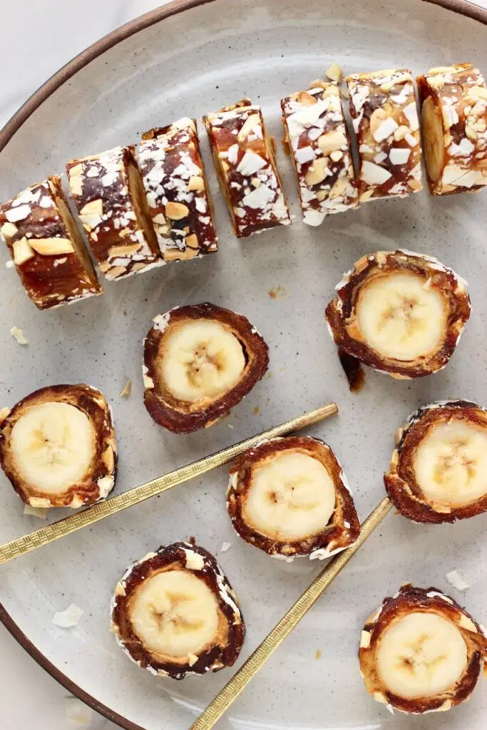 Banana sushi slices being held with chop sticks.