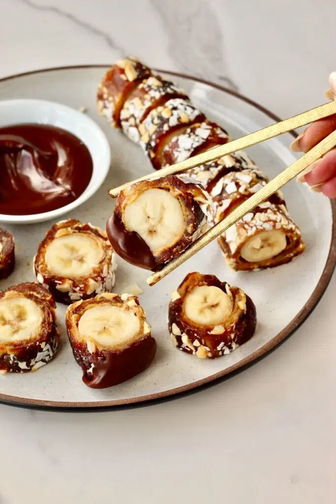 Chop sticks holding the banana sushi 