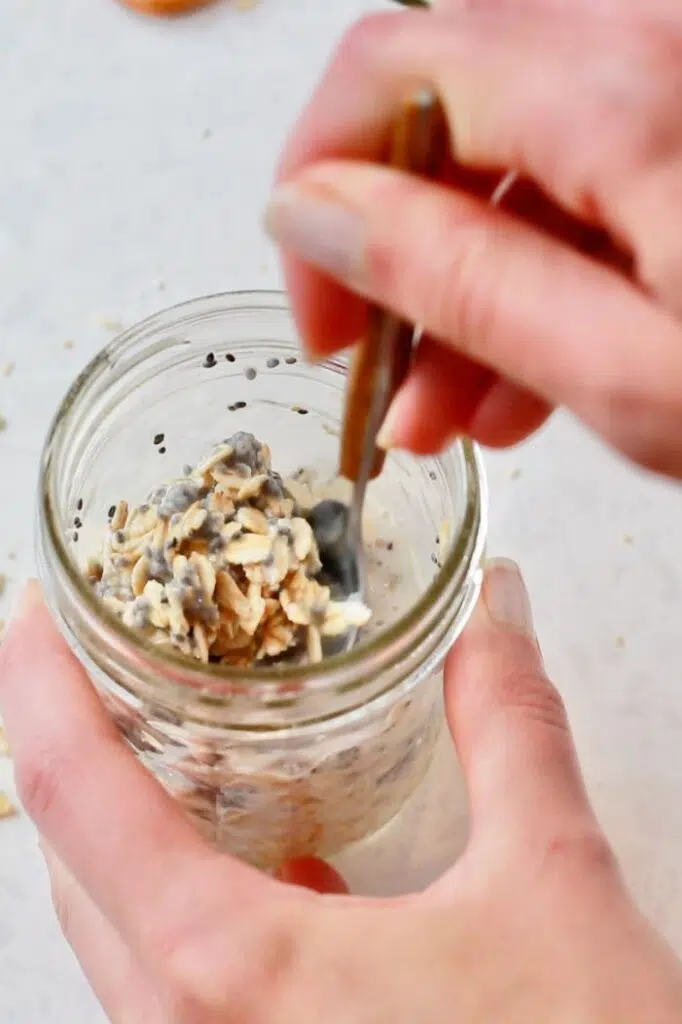 Mixing oats, milk, and chia seeds in mason jar