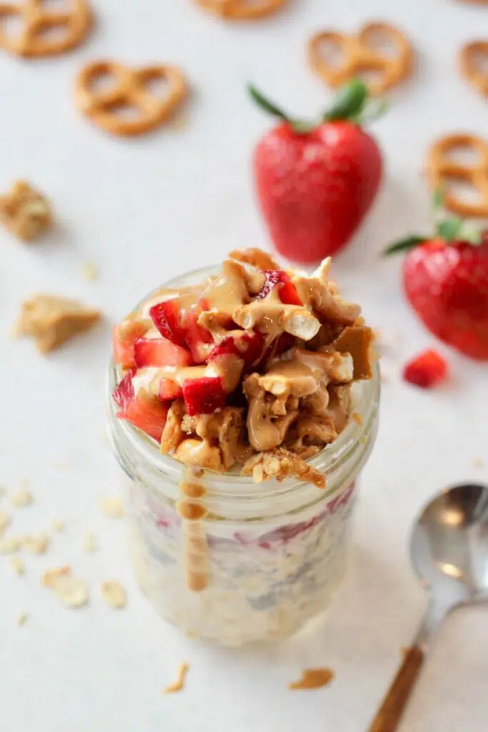 Strawberry overnight oats in jar with pretzels crumbles on top