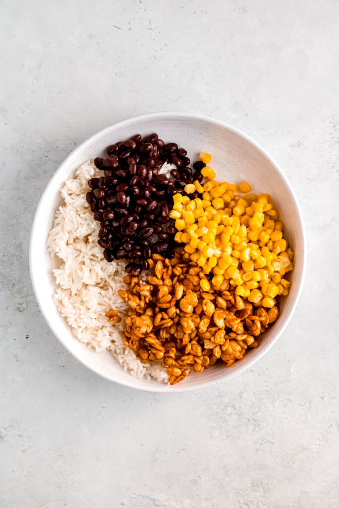 Rice, tempeh, black beans, and corn in white bowl