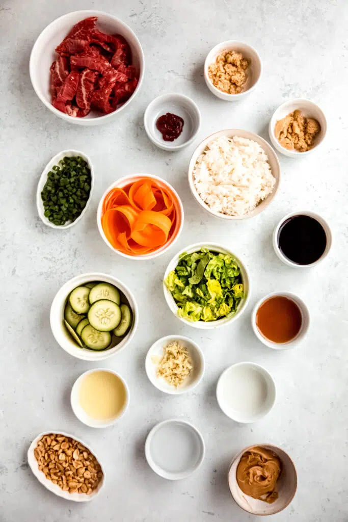 Ingredients in separate white bowls to make bulgogi-inspired bowl with gochujang peanut sauce