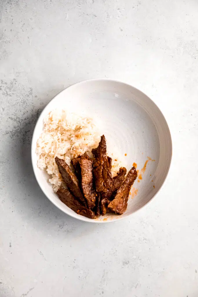 White rice and steak in white bowl