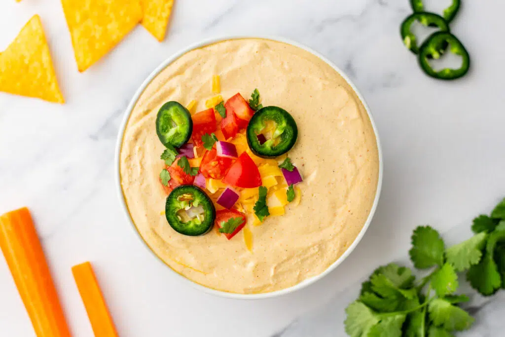 High Protein Cottage Cheese Queso Dip topped with fresh veggies for garnish