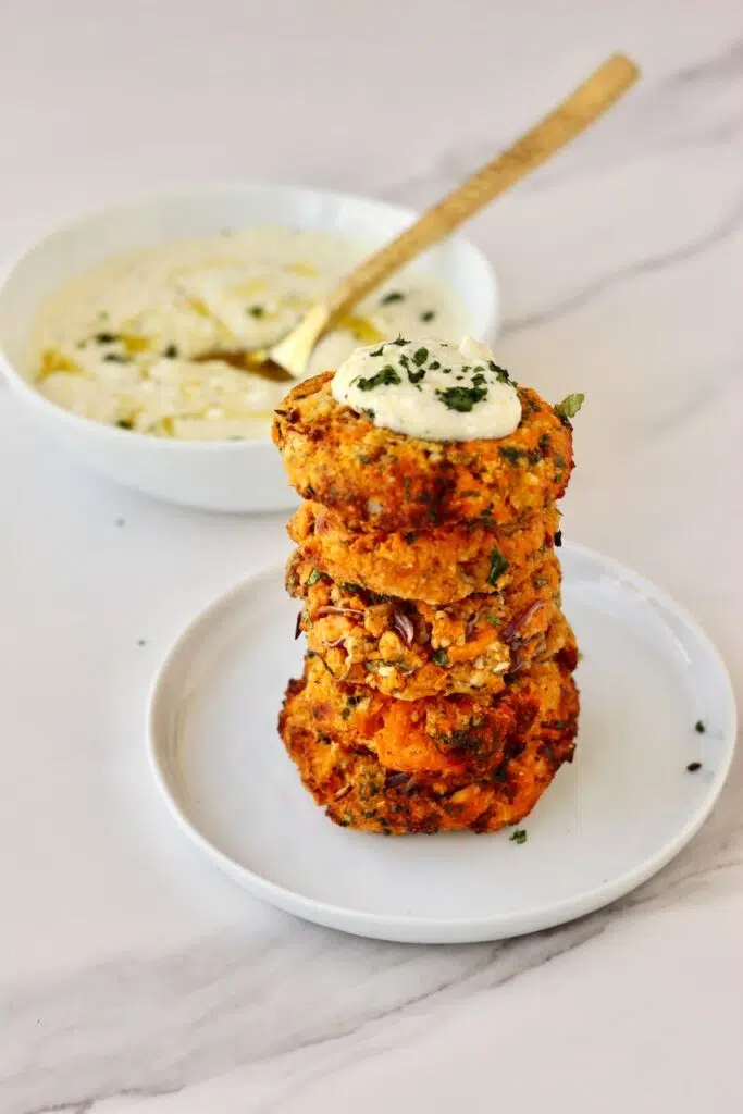 Stack of sweet potato patties with feta dip