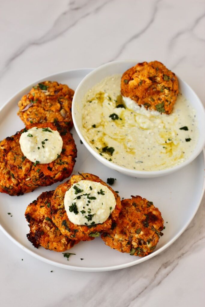 Sweet potato patties with feta dip  on top of patties 